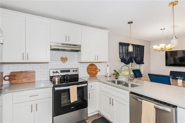 200 Robin Hood Ln, Hampton, GA 30228 - kitchen with stainless steel appliances, under cabinet range hood, a chandelier, a peninsula, and decorative backsplash