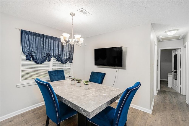 200 Robin Hood Ln, Hampton, GA 30228 - dining area featuring wood finished floors, a chandelier, and a textured ceiling