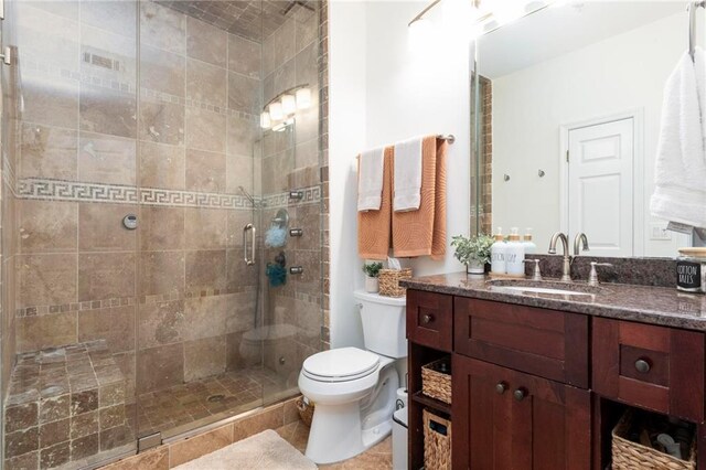 bathroom featuring vanity, toilet, and walk in shower