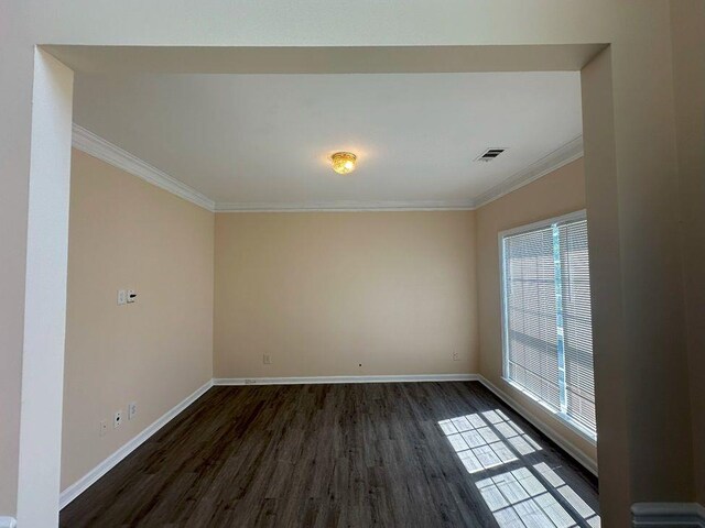 empty room with ornamental molding and dark wood-type flooring