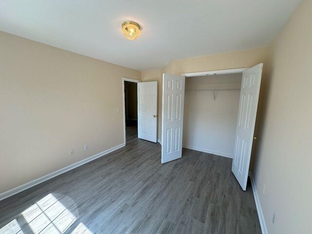 unfurnished bedroom with hardwood / wood-style flooring and a closet