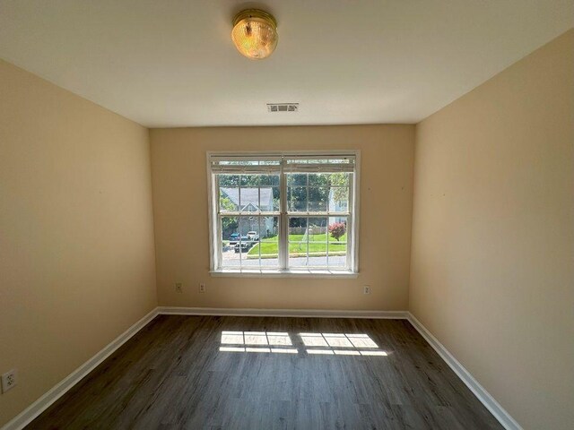 empty room with dark hardwood / wood-style flooring