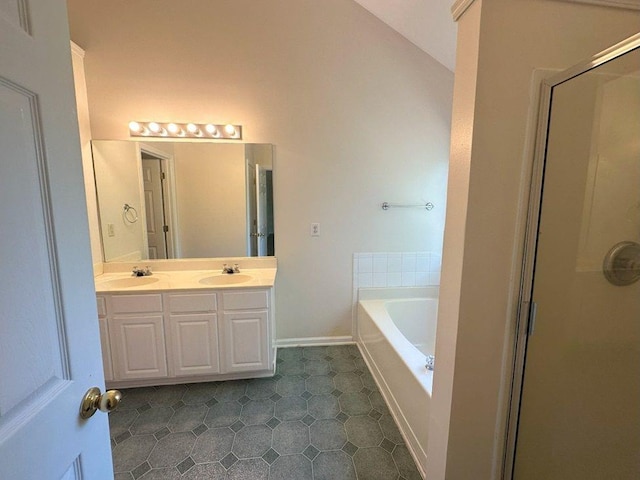 bathroom with double vanity, lofted ceiling, separate shower and tub, and tile patterned floors