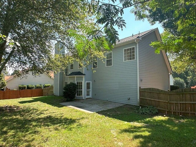 rear view of property featuring a patio and a yard