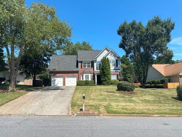 view of property featuring a garage and a front yard