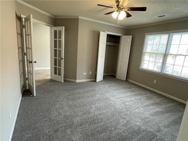 7123 Woodridge Ln, Union City, GA 30291 - unfurnished bedroom with french doors, a textured ceiling, ornamental molding, carpet floors, and a closet