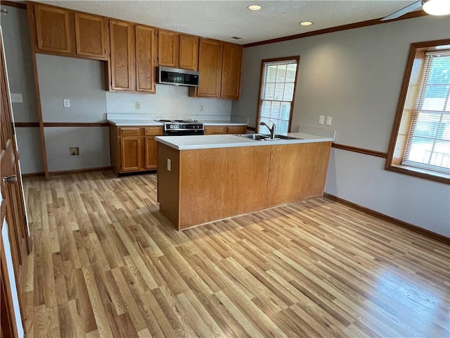 7123 Woodridge Ln, Union City, GA 30291 - kitchen with stainless steel microwave, brown cabinets, a peninsula, black range oven, and light wood-style floors