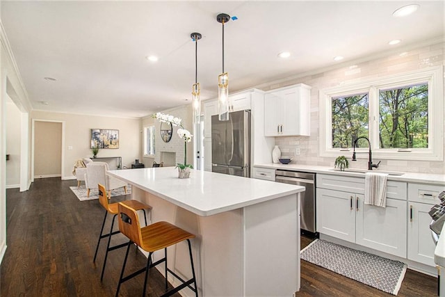 9640 Cedar Grove Rd, Fairburn, GA 30213 - kitchen featuring stainless steel appliances, a sink, a kitchen island, decorative backsplash, and a breakfast bar