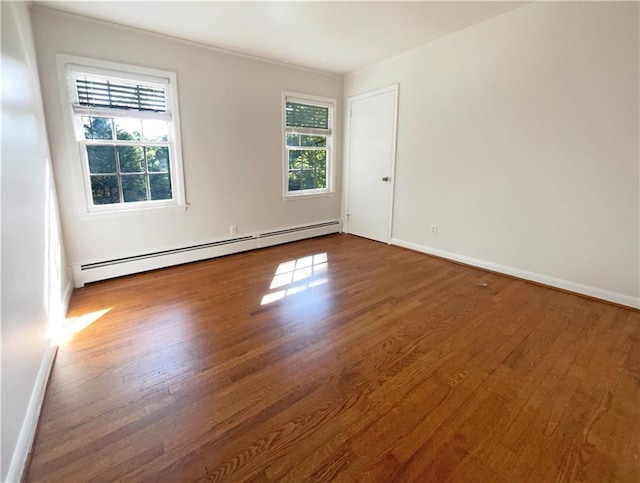 empty room featuring a baseboard radiator and dark hardwood / wood-style floors