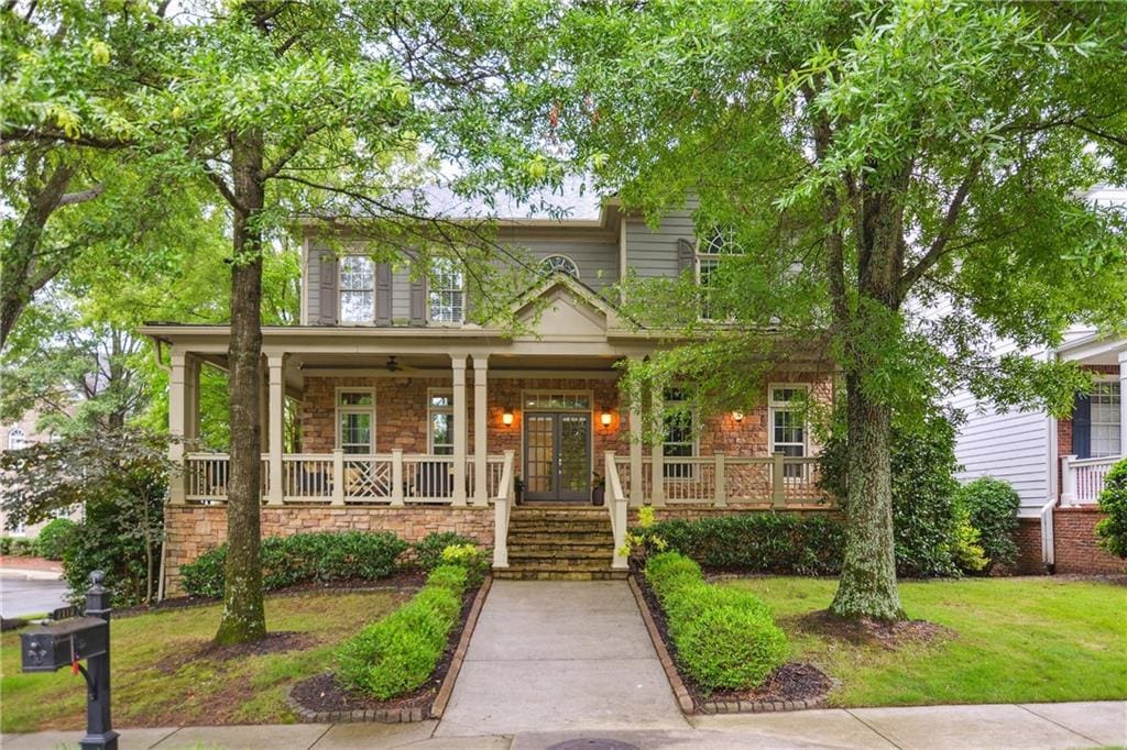 2112 Murren Dr SE, Smyrna, GA 30080 - view of front of home with a porch, french doors, stone siding, a front lawn, and stairs