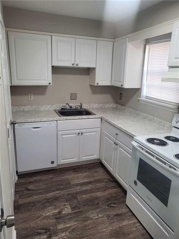 kitchen with dark hardwood / wood-style floors, light stone countertops, white appliances, sink, and white cabinets