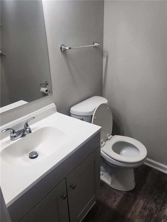 bathroom with toilet, hardwood / wood-style flooring, and vanity