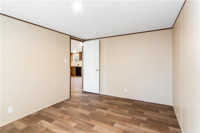 empty room featuring crown molding and hardwood / wood-style floors