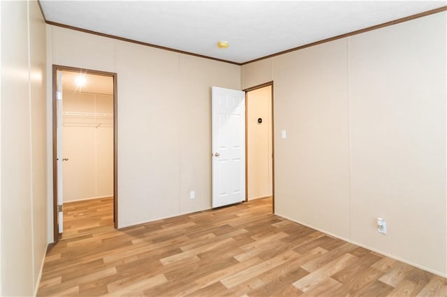 unfurnished room featuring crown molding and light hardwood / wood-style flooring