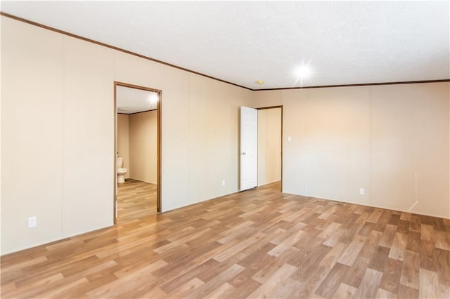 unfurnished room featuring crown molding and light hardwood / wood-style floors