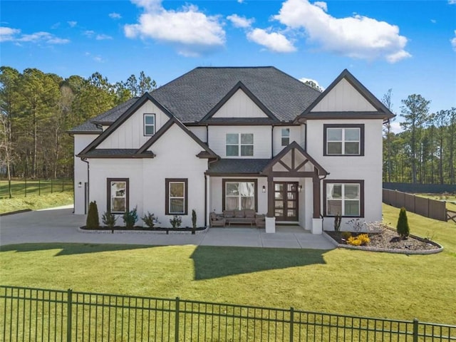 view of front of home with a shingled roof, a front lawn, french doors, and fence private yard