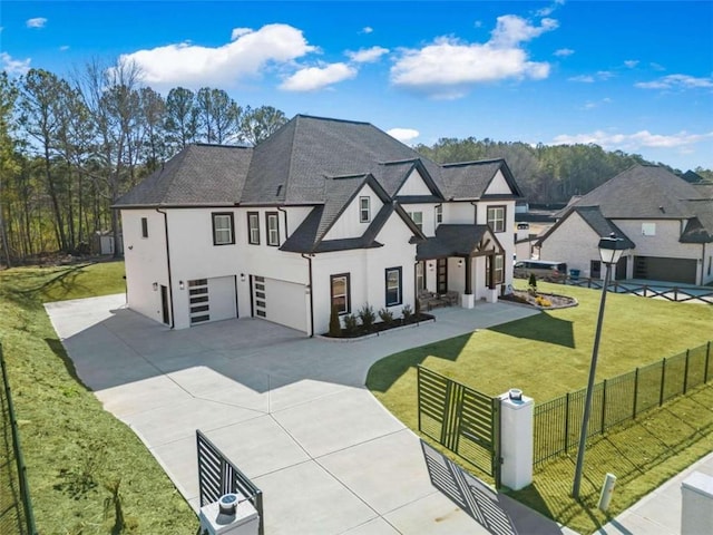 view of front of home with a front yard, stucco siding, concrete driveway, a garage, and a fenced front yard