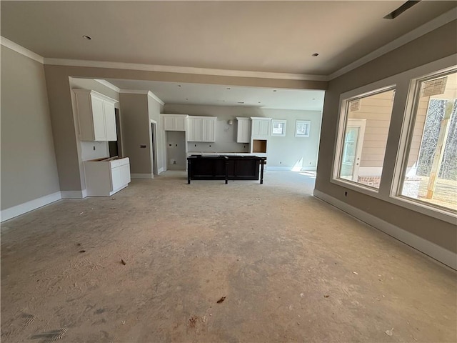 unfurnished living room featuring baseboards and crown molding