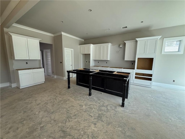 kitchen with white cabinets, visible vents, and baseboards