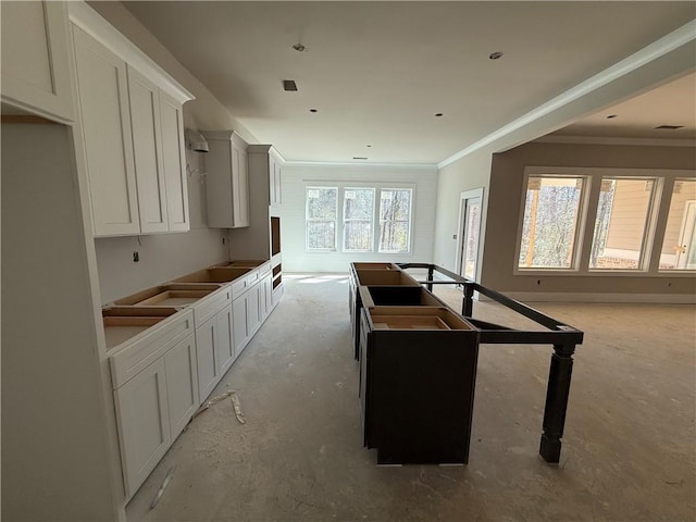 kitchen with a center island, white cabinetry, and crown molding