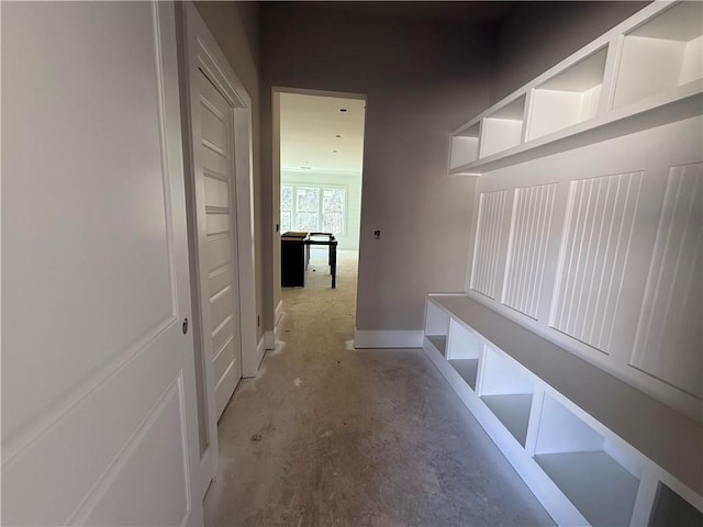 mudroom featuring baseboards and unfinished concrete floors