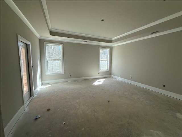 empty room featuring ornamental molding, a raised ceiling, visible vents, and baseboards