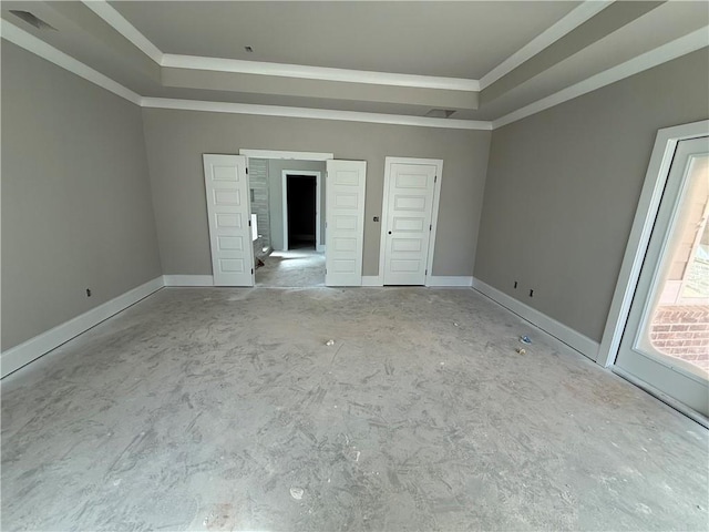 unfurnished bedroom featuring baseboards, visible vents, a tray ceiling, and crown molding