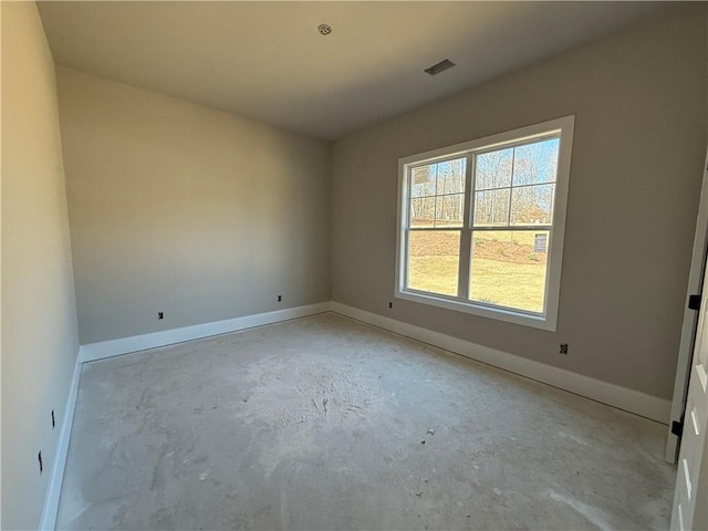 empty room with baseboards, unfinished concrete floors, and visible vents