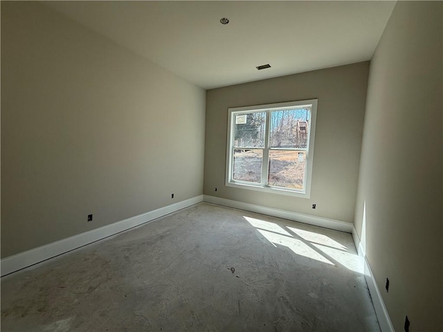 empty room featuring concrete flooring, visible vents, and baseboards