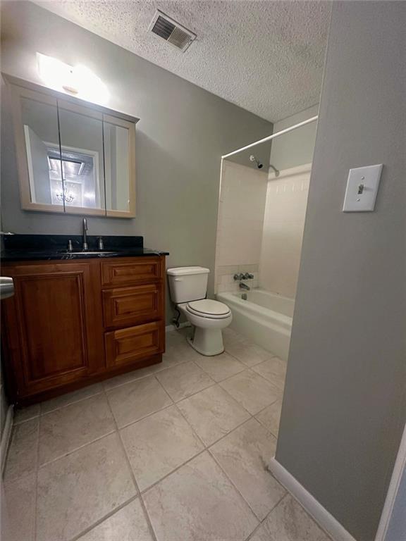 4701 Flat Shoals Rd, Union City, GA 30291 - full bath with a textured ceiling, vanity, bathtub / shower combination, and tile patterned floors