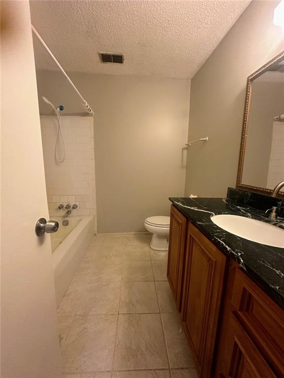 4701 Flat Shoals Rd, Union City, GA 30291 - full bath featuring a textured ceiling, tile patterned floors, vanity, and tub / shower combination
