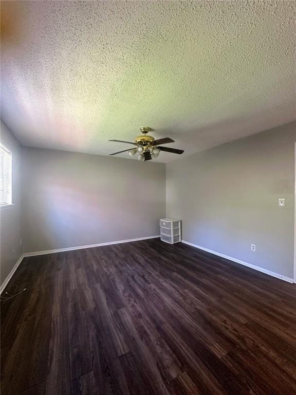 4701 Flat Shoals Rd, Union City, GA 30291 - unfurnished room featuring dark wood-type flooring, a textured ceiling, and ceiling fan