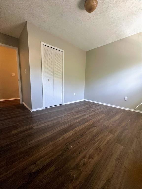 4701 Flat Shoals Rd, Union City, GA 30291 - unfurnished bedroom with dark wood-style floors, a textured ceiling, and a closet