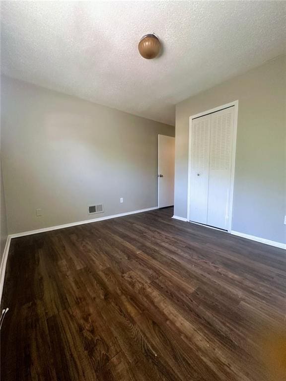 4701 Flat Shoals Rd, Union City, GA 30291 - unfurnished bedroom with dark wood-type flooring, a closet, and a textured ceiling