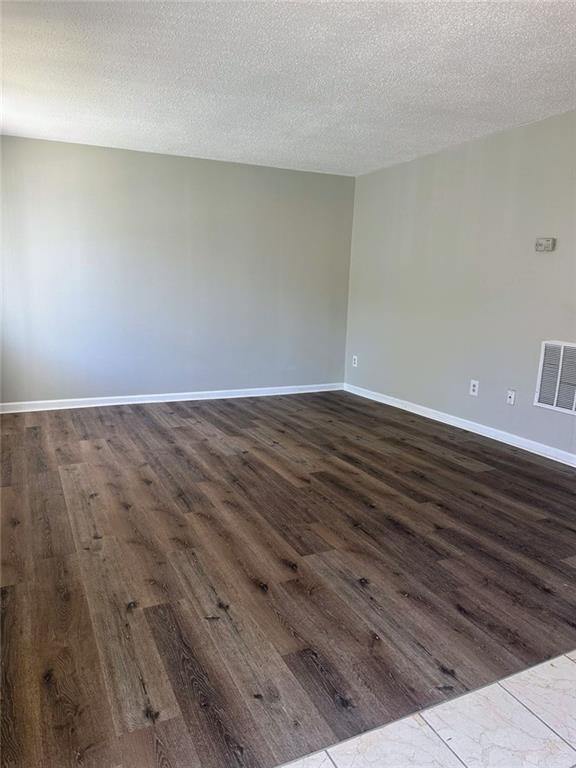 4701 Flat Shoals Rd, Union City, GA 30291 - spare room featuring dark wood-style floors and a textured ceiling