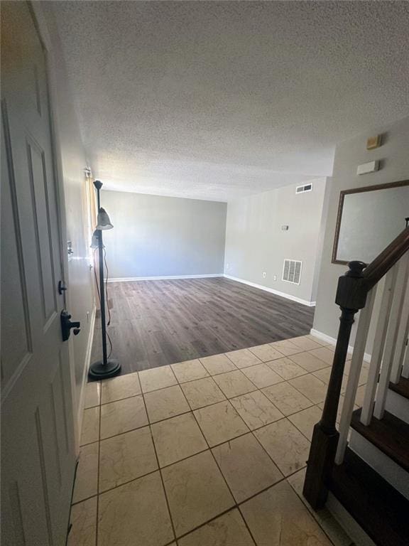 4701 Flat Shoals Rd, Union City, GA 30291 - unfurnished room featuring a textured ceiling, stairway, and tile patterned floors