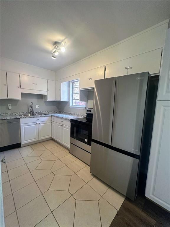 4701 Flat Shoals Rd, Union City, GA 30291 - kitchen with appliances with stainless steel finishes, white cabinetry, light tile patterned flooring, and light stone countertops