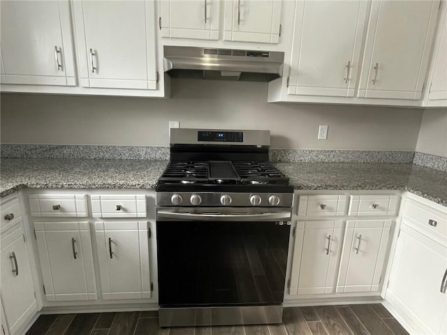 kitchen with gas range, light stone countertops, wood tiled floor, under cabinet range hood, and white cabinetry