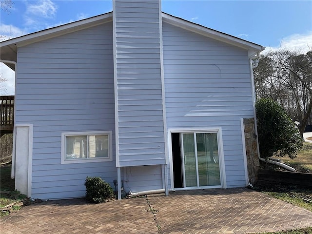 back of property with a patio and a chimney