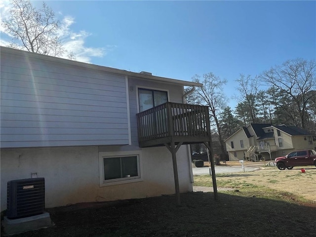 view of side of property featuring central air condition unit and stucco siding