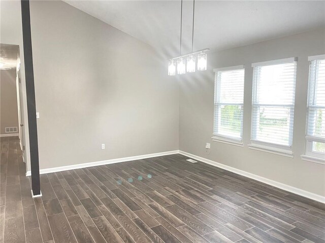 spare room with dark wood-style floors, vaulted ceiling with beams, and baseboards