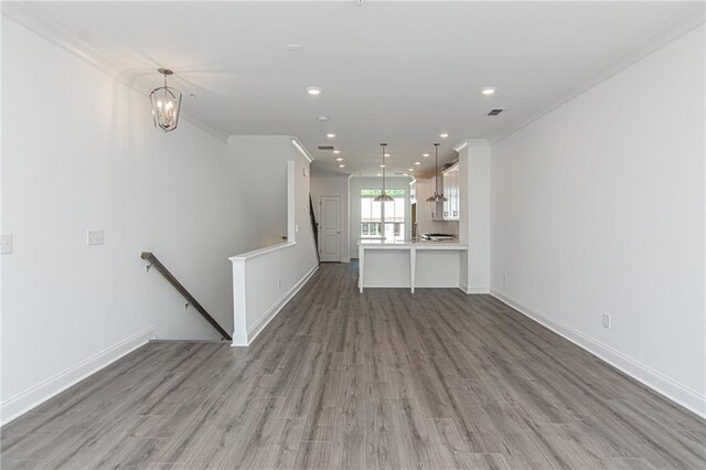 unfurnished living room with crown molding and hardwood / wood-style flooring