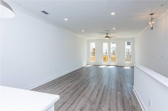 unfurnished living room featuring french doors, hardwood / wood-style flooring, ornamental molding, and ceiling fan with notable chandelier