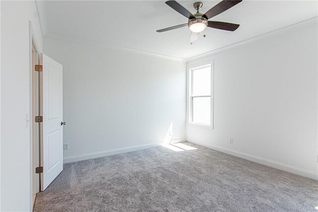 carpeted spare room featuring ornamental molding and ceiling fan