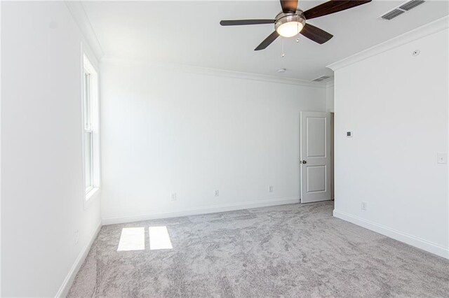 empty room with light carpet, ornamental molding, and ceiling fan