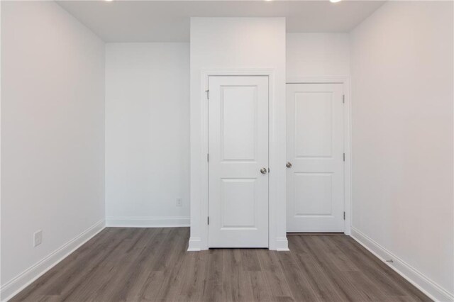 unfurnished bedroom featuring a closet and dark hardwood / wood-style flooring