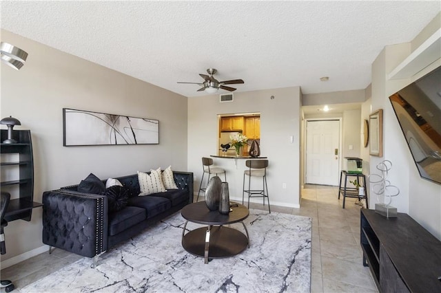 1280 W Peachtree St NW Unit 810, Atlanta, GA 30309 - living room featuring visible vents, a ceiling fan, a textured ceiling, and light tile patterned floors