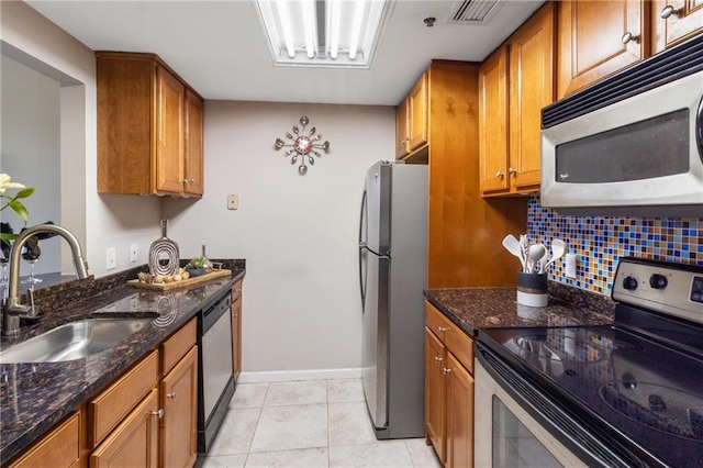 1280 W Peachtree St NW Unit 810, Atlanta, GA 30309 - kitchen with brown cabinetry, a sink, dark stone counters, and appliances with stainless steel finishes