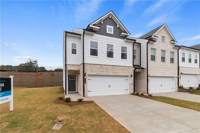 view of property featuring a garage, driveway, brick siding, and a front lawn