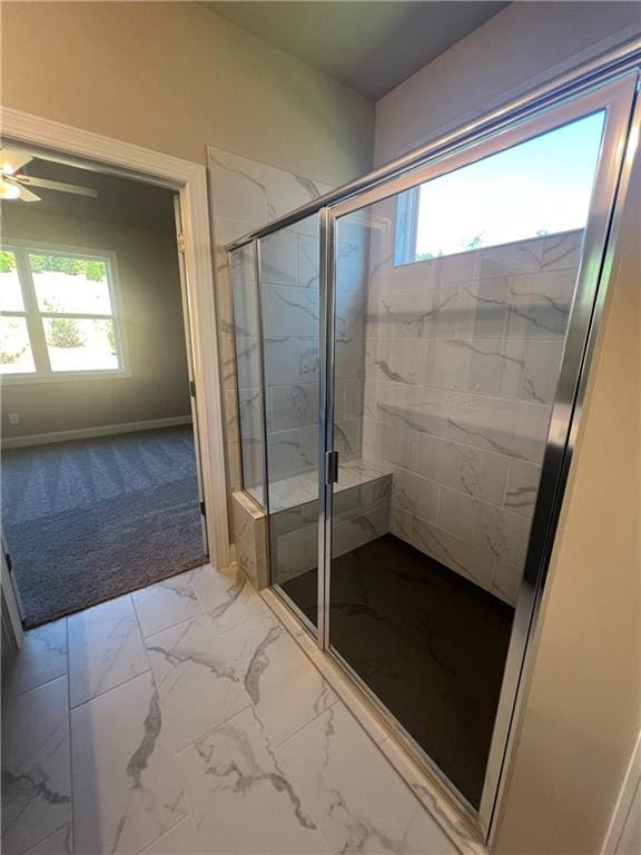 bathroom featuring plenty of natural light, ceiling fan, and a shower with shower door